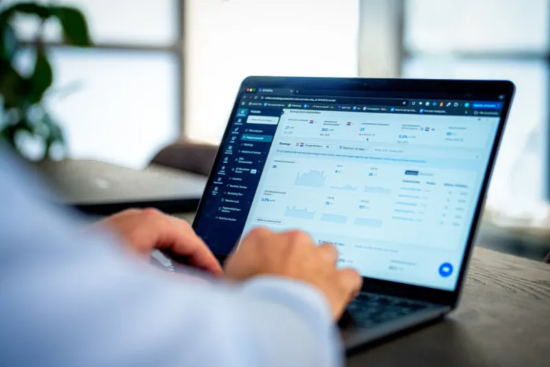 Close-up van een persoon die werkt op een laptop met een SEO-analysetool geopend op het scherm.